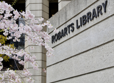 The Robarts Library building sign behind pink cherry blossoms