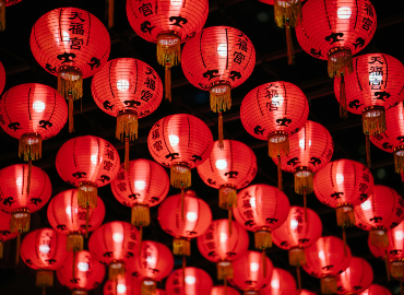 Red lanterns with Chinese characters hang from a ceiling.