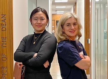 Student Chelsea Wang and Dean Melanie Wood posing with arms crossed facing the camera